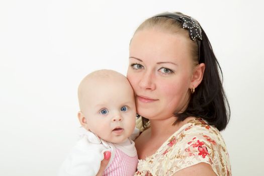 infant in the arms of the mother on a light background
