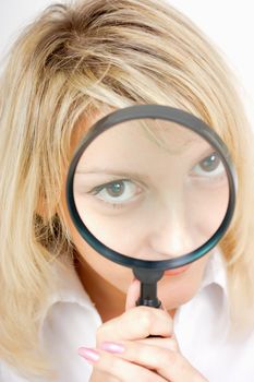 girl with a magnifying glass on a light background
