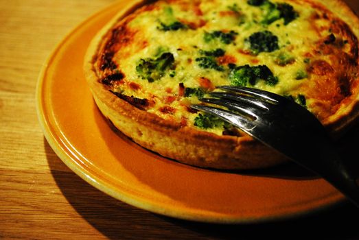 A quiche with for stuck in it.