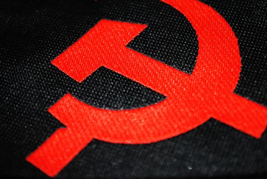 Red hammer and sickle on black background.