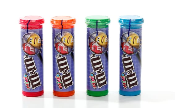 Containers of sealed M&M's minis.  Small round shaped chocolate coated in a colourful candy shell.