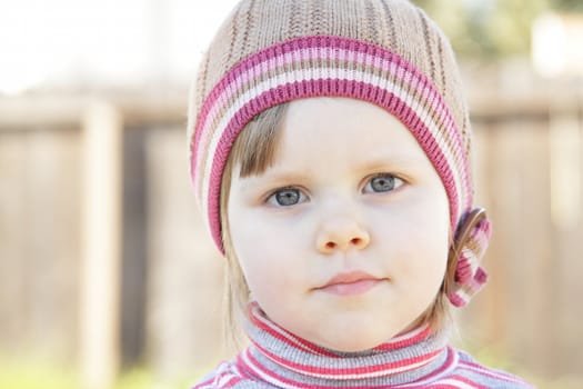 Closeup photo of a cute toddler girl with a knit hat