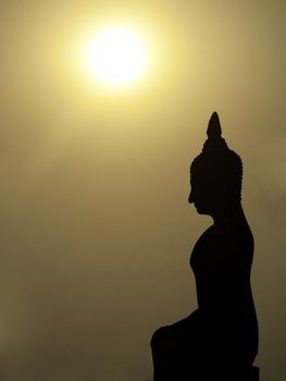 Silhouette of Buddha statue at sunset in Wat Mahathat in Sukhothai Thailand