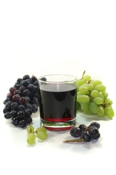 Grape juice with light and dark grapes on a white background
