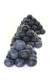 three pyramids of fresh blueberries on a white background