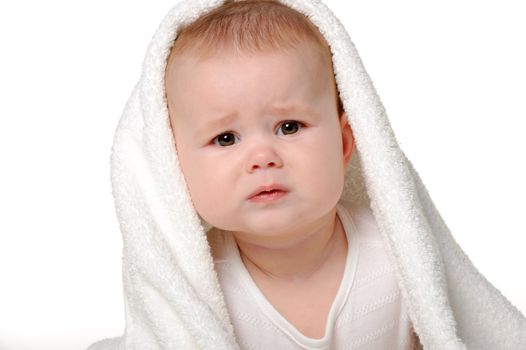 The crying baby under a towel. Age of 8 months. It is isolated on a white background