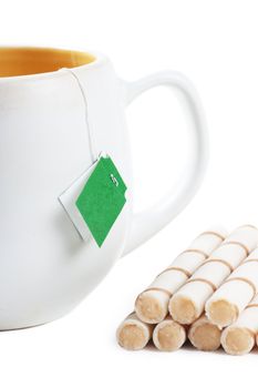 Closeup view of handle of cup and sweets over white background