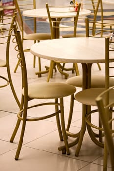 Cafe tables and chairs close to shopping center.