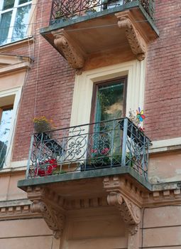 Facade of a building with a balcony and flowers. The building is constructed 1850-1890