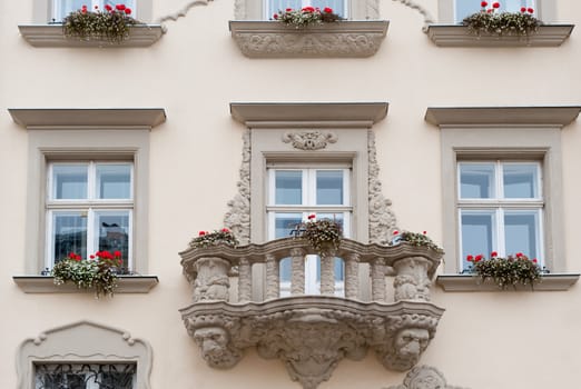 Facade of a building with a balcony and flowers. The building is constructed 1850-1890