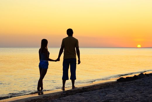 Couple silhouette on the beach at sunset 