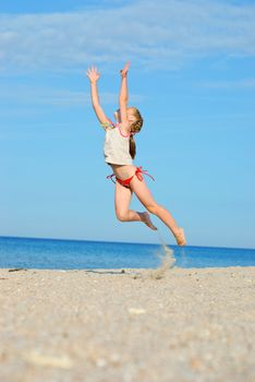 Jumping little girl on the beach