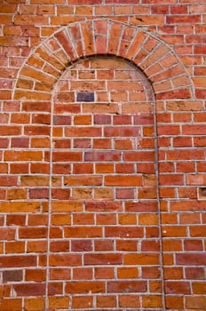 Arch with rounded top mured up with red brick. Architectural wall solutions.