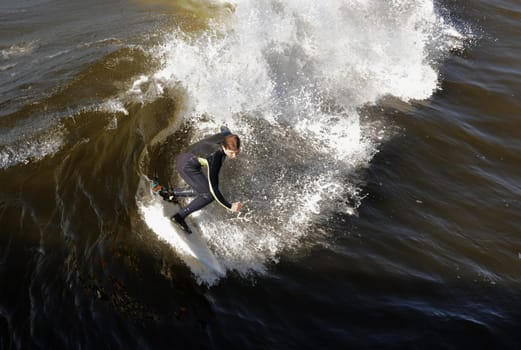 Surfer gets up on a wave. The wave twists with foam and splashes.