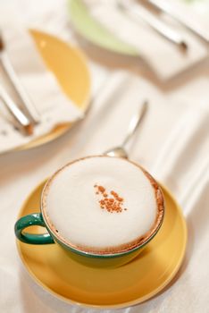 Single cup of coffee on table with bright light.