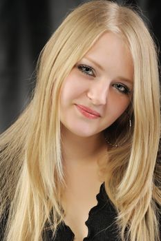 Portrait of the pretty young girl of the blonde. On a black background