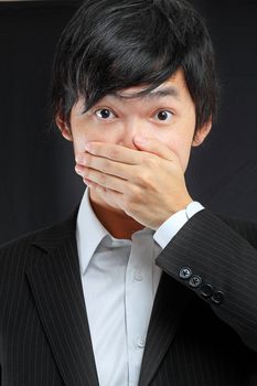 scared adult man with hand covering mouth 