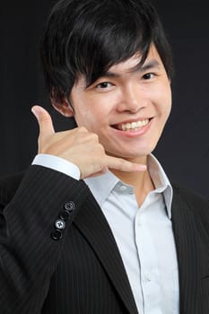 Closeup of young asian man making call me gesture