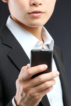 business man in black suit working on pda or smartphone 