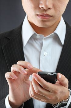 business man in black suit working on pda or smartphone 