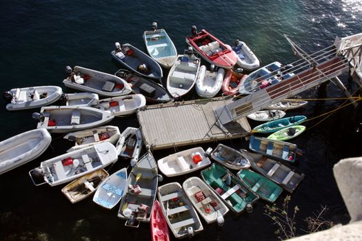 A wreath of dingys surround a dock in Avalon Bay, Catalina Island, California.