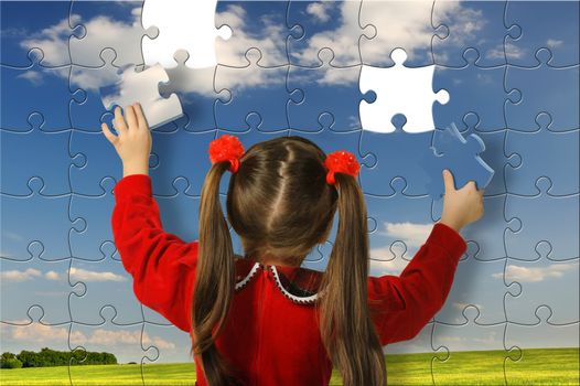 The girl assemble big puzzle. Landscape on a picture
