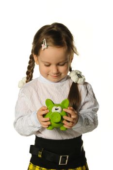 The little girl with a money box - a pig. It is isolated on a white background