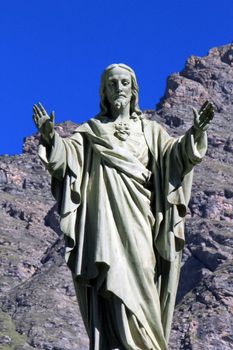 Jesus statue made of white stone in front of a rock at Bessans, France