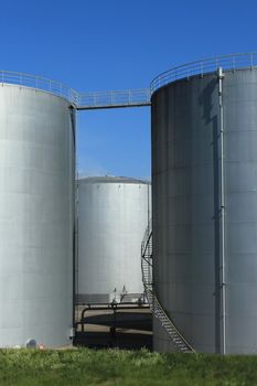 Big grey oil tanks and blue sky