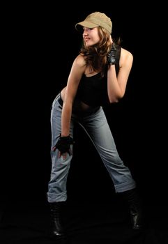 The woman in jeans and a stylish cap on a black background