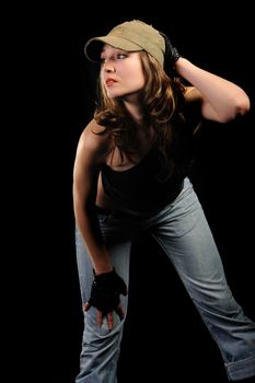 The woman in jeans and a stylish cap on a black background