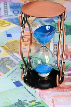 Time of money. A sand-glass and the European currency
