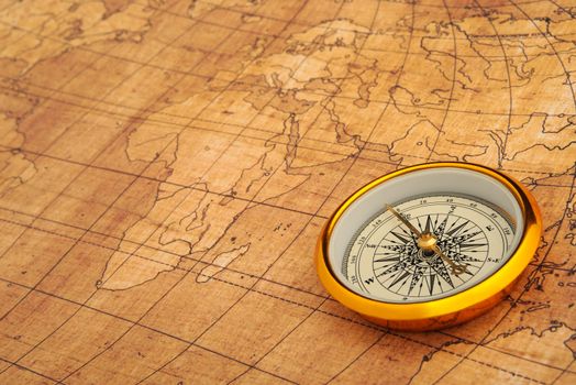 Compass on old map. Gold comapss and yellow map