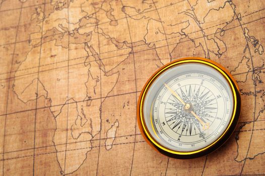 Compass on old map. Gold comapss and yellow map