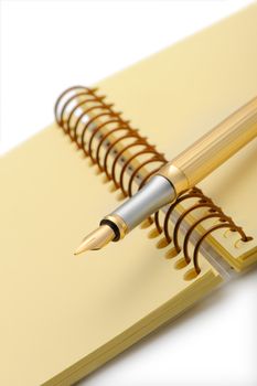 Fountain pen on a yellow notebook. Photo closeup