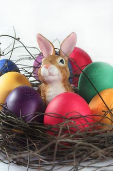 Easter basket with Easter eggs and Easter bunny bright background