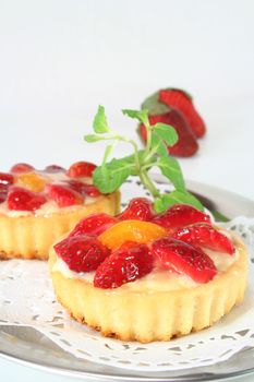 Strawberry tarts with mint on a silver platter