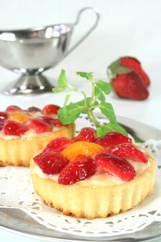 Strawberry tarts with mint on a silver platter