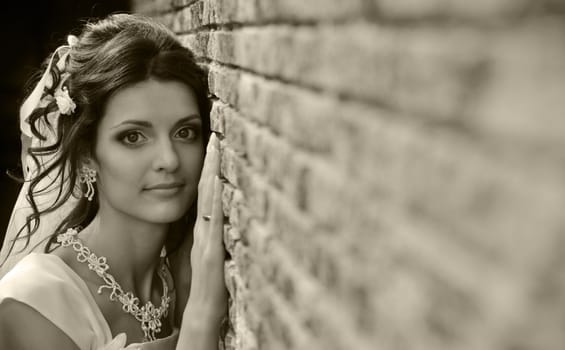 The bride at a wall. The young girl in a wedding dress.