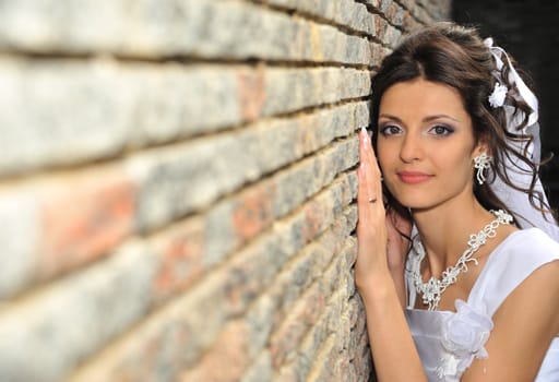 The bride at a wall. The young girl in a wedding dress.
