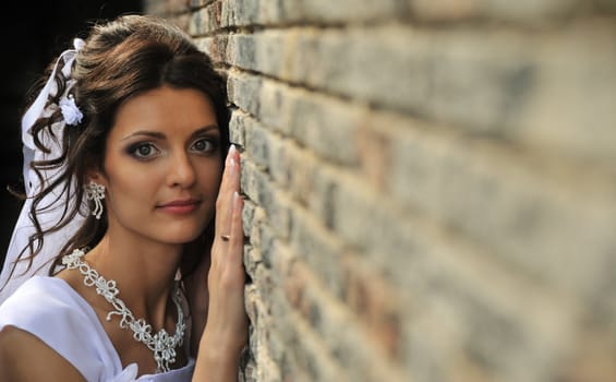 The bride at a wall. The young girl in a wedding dress.