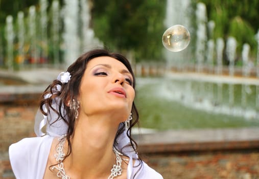 The bride and soap bubbles. The young girl in a wedding dress.