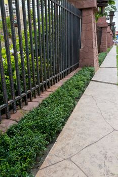 Walkway beside the fence, steel and stone walls of the hotel.