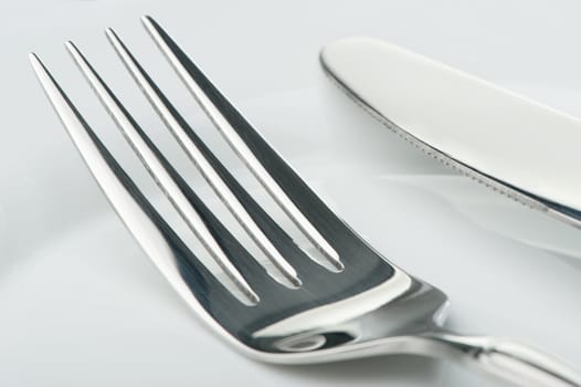 Knife and fork on a plate. Kitchen accessories close up
