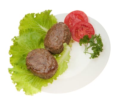 Cutlets with vegetables on a plate. It is isolated on a white background