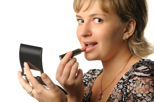 The young girl does a make-up. Paints lips