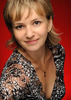 Portrait of the young girl on a red background. The European appearance