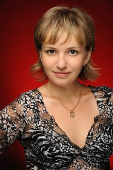 Portrait of the young girl on a red background. The European appearance