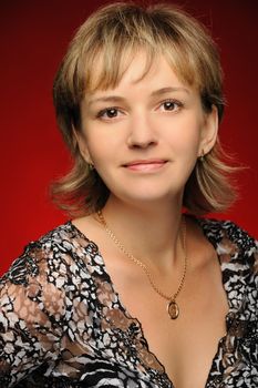 Portrait of the young girl on a red background. The European appearance