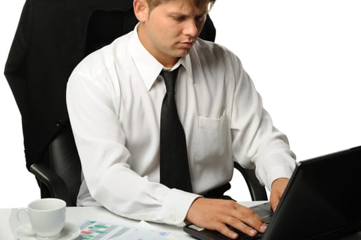 The young businessman on a workplace. It is isolated on a white background